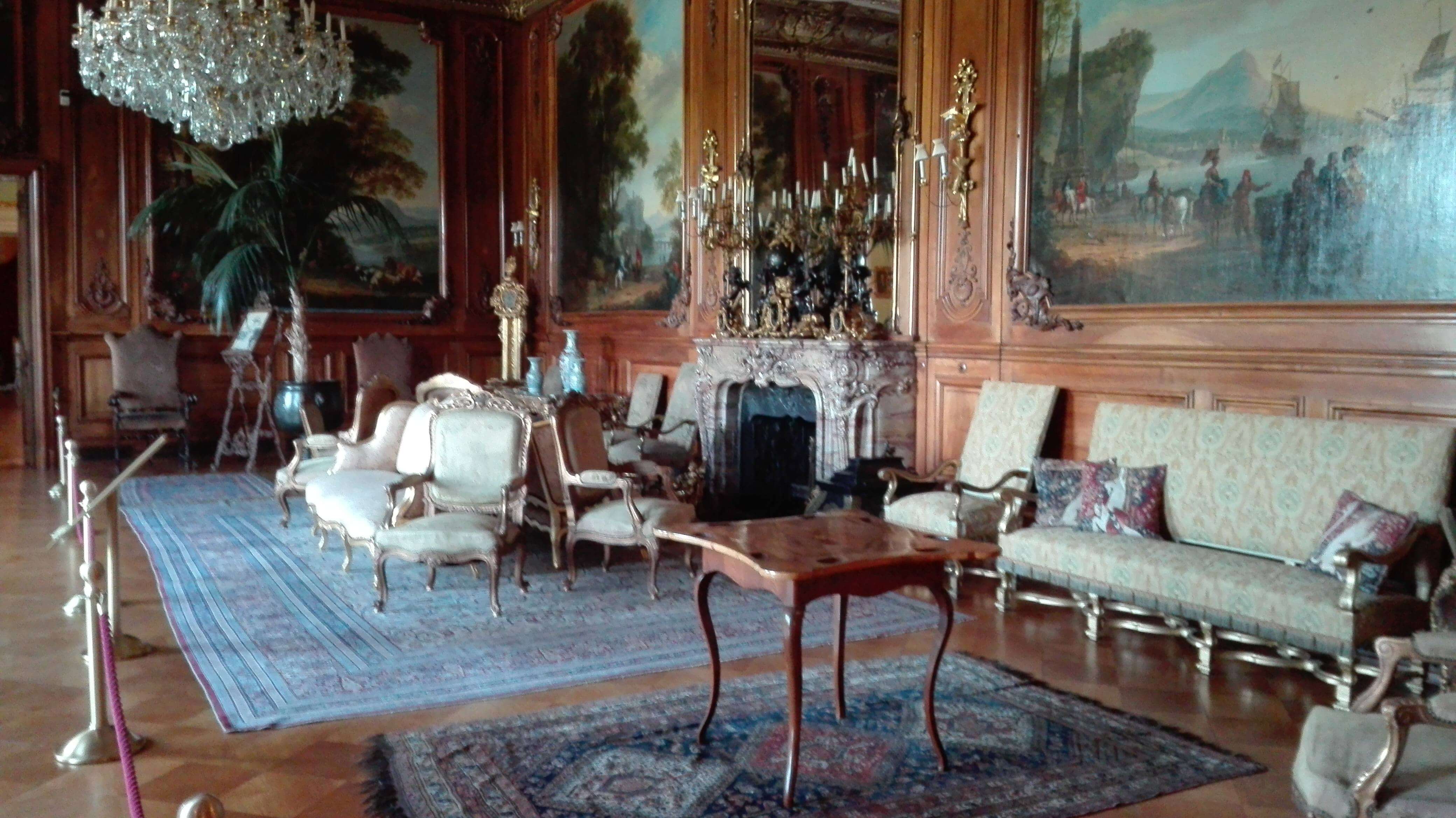 salon w rezydencji z obrazami i ornamentalnymi dywanami