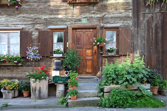 kwiaty i rośliny przed wejściem do starego drewnianego domu