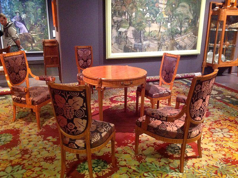 wnętrze z wzorzystym dywanem i tapicerką na krzesłach