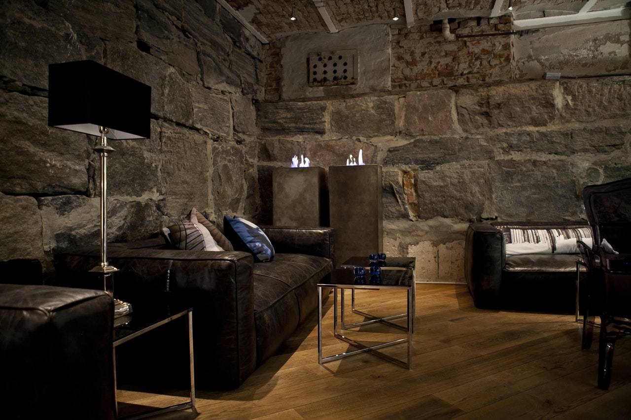 salon z kamienną ścianą i drewnianą podłogą