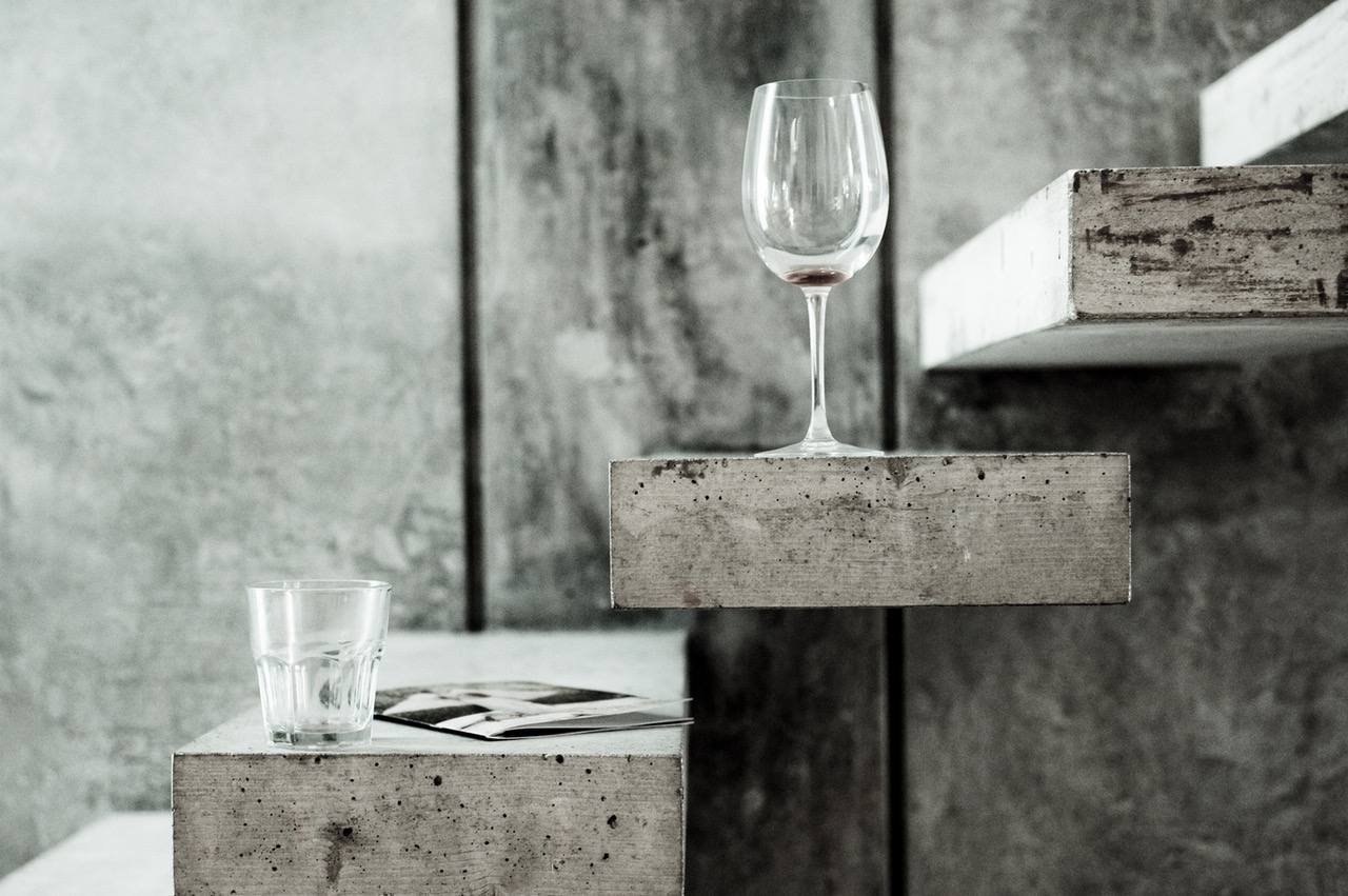 kieliszek wina i szklaneczka na betonowych stopniach